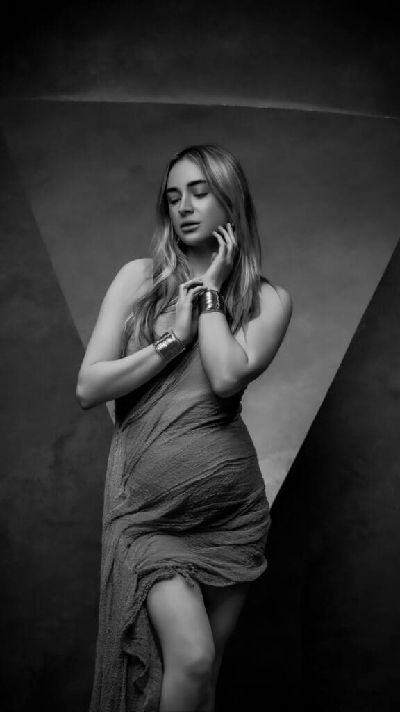 Pregnant woman cradling her five-month baby bump during a black-and-white maternity portrait session photographed by Tobi Rose Photography in Hood River, Oregon
