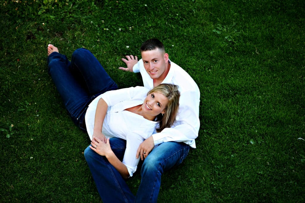 Engaged couple cuddling together in a blue chair during an outdoor engagement session photographed by Tobi Rose Photography