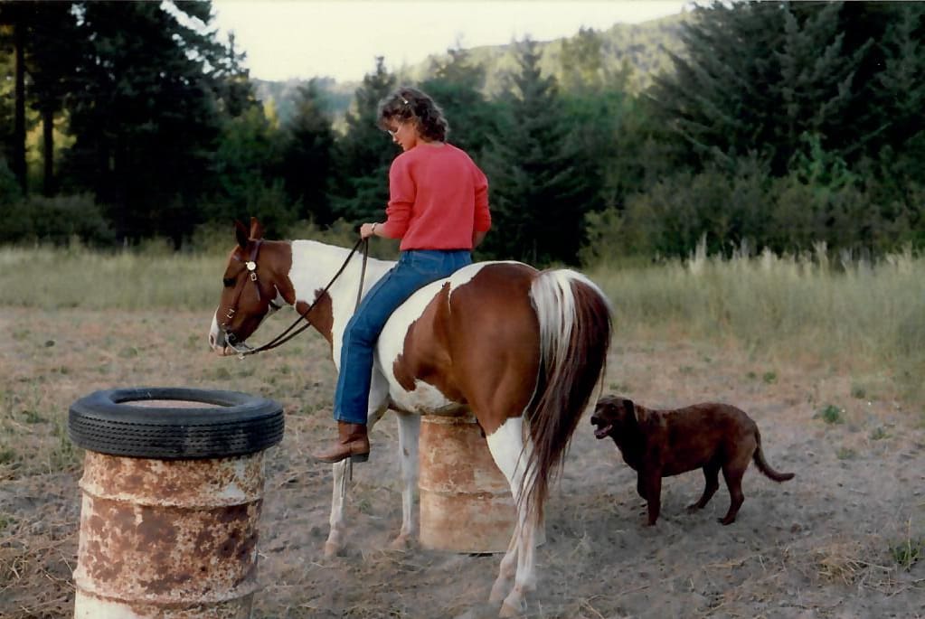 Tobi Rose Rabaliati riding her horse Shadow with her Chesapeake Bay Retriever Daisy in the Columbia River Gorge