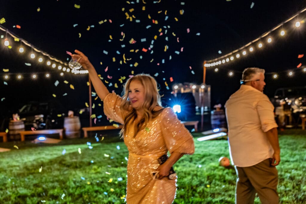 Letty celebrating her 50th birthday under string lights and colorful confetti at an outdoor party in Hood River, Oregon, photographed by Tobi Rose Photography.