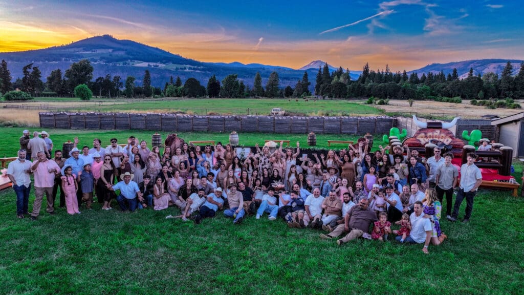 Aerial drone photograph of all the guests at Letty’s 50th birthday party, including family, friends and children, with Mount Adams at sunset in Hood River, Oregon, by Tobi Rose Photography.