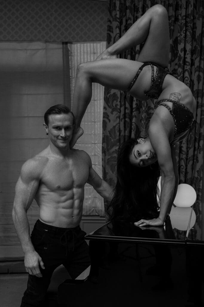Holland Lohse and Sienna Martinez demonstrate an acrobatic pose on a grand piano during Jennifer Bruno Smith’s 5K Flow Posing Class at WPPI 2026 in Las Vegas.