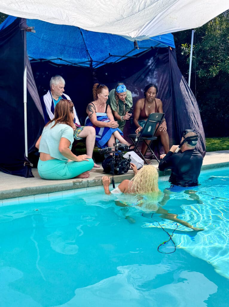 Brett Stanley and Hannah Fraser in the pool while Tobi Rose Rabaliati and workshop students watch underwater photographs appear on a monitor during Brett Stanley’s underwater photography workshop
